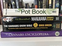 Stack of four cannabis-themed books showing spines with titles and authors