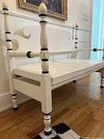 Full view of white wooden jester bench showing seat, backrest, legs and decorative finials