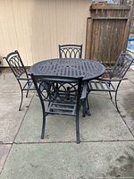 round metal table with four matching chairs on patio