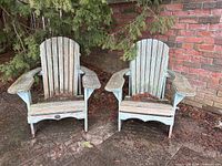 Two teal-stained wooden Muskoka chairs on patio