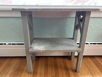 front view of grey wooden side table showing top and lower shelf