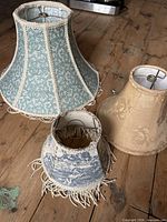 All three vintage fabric lampshades on wooden floor