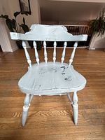 Full view of blue distressed wooden chair on hardwood floor