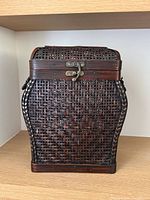Front view showing rattan weave, wood frame, brass latch