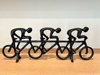 Side view showing entire sculpture and three cyclists