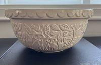 Side view showing fox forest embossing and scalloped rim