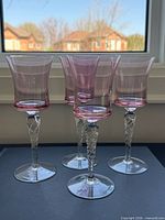 Front view of four coral pink cordial glasses showing bowl shape and stem design