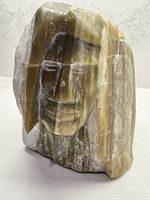 Oblique front view showing carved face and stone coloration