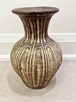 Full view of terracotta vase showing shape, ribbed pattern and finish