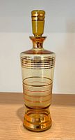 Full view of amber glass decanter with stopper