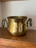 Full view of hammered brass pot showing shape and both dragon handles
