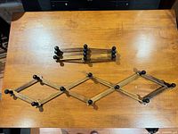 Both wooden accordion racks shown, one extended one folded