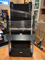 Front view of folded Altrax AX T80 treadmill wrapped for storage
