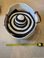 Top view of basket with hat inside and tape measure showing width