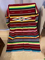 One of the striped acrylic blankets draped to show pattern and fringe
