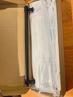Box containing matte black handle and sealed bags of remaining handles
