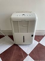 Front view of Diplomat dehumidifier showing grille and water tank slot