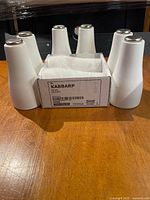 Six loose white tapered legs and a sealed two-pack box displayed on tabletop