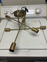 Fixture resting on washer showing full six-arm structure and sockets