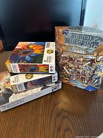 Four boxed 1000-piece puzzles on table