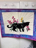 front view of quilt showing cat and flowers design