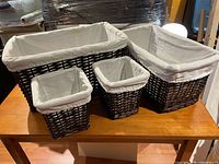 All four dark brown woven baskets with cream liners displayed on table