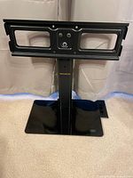 Front view showing full stand with mounting bracket, column, and glass base