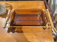Amber glass baking dish seated in wood trivet