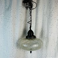 Full view of hanging crackle glass swag light with chain