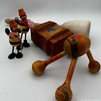 Group shot of all wooden items: two bee figurines, Magic Box, mallet, massager