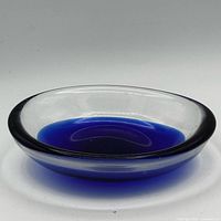 Full view of shallow clear-rimmed bowl with cobalt blue interior