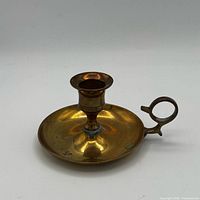 Angled view showing full brass chamberstick with loop handle