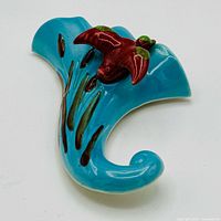 Front view showing turquoise wall pocket and red duck ornament