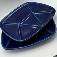 Stacked cobalt blue sectioned plates showing overall shape and compartment layout