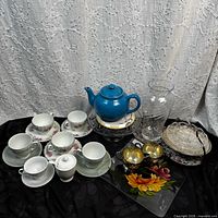 Group shot of entire lot showing teapot, teacups, glass pieces, silver creamers, covered dish