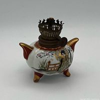 Front view showing geisha scene, brass burner, red and gold trim