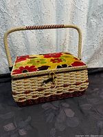Wicker sewing basket closed showing floral velvet lid and handle
