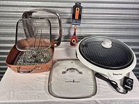 Overview of all items: Copper Chef pan with inserts, Magic Chef grill with lid and control probe, glass pan lid, painted spoon