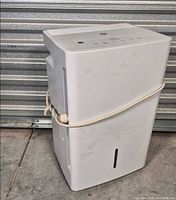 Angled front view of GE dehumidifier showing overall condition and water-tank slot