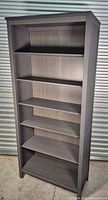 Front view of gray bookcase showing six shelves