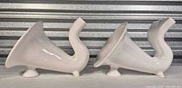 Side view of both white ceramic horn speakers showing shape and finish