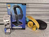 Group shot of all items: Beats headphones with case, Panasonic earphones, LED stand box