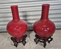 front view of both red vases on stands