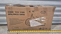 Closed cardboard box labeled Kids’ Toy for Balance Dino showing graphics and age range
