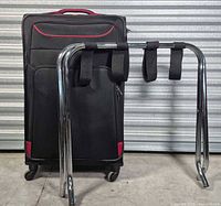 Front view of three suitcases and folded luggage stand