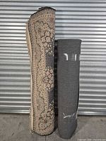 Two rolled rugs standing upright