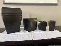 Front view of all four bathroom accessories lined up on towel