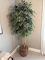 Full view of artificial potted tree showing foliage, trunk and decorative pot