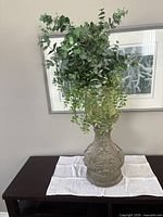 Front view of urn pedestal with faux greenery displayed