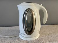 Profile view of kettle showing body, handle, stainless trim, cord